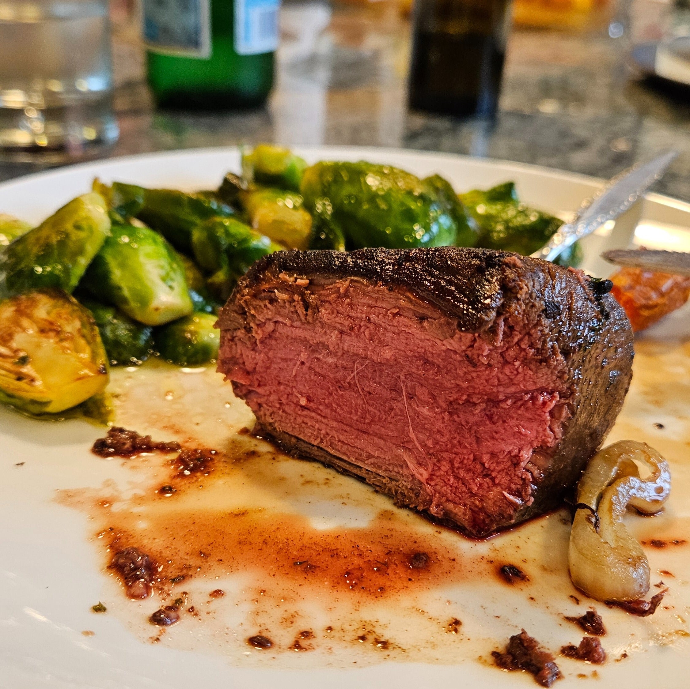 sliced reverse seared filet mignon with roasted vegetables on a plate