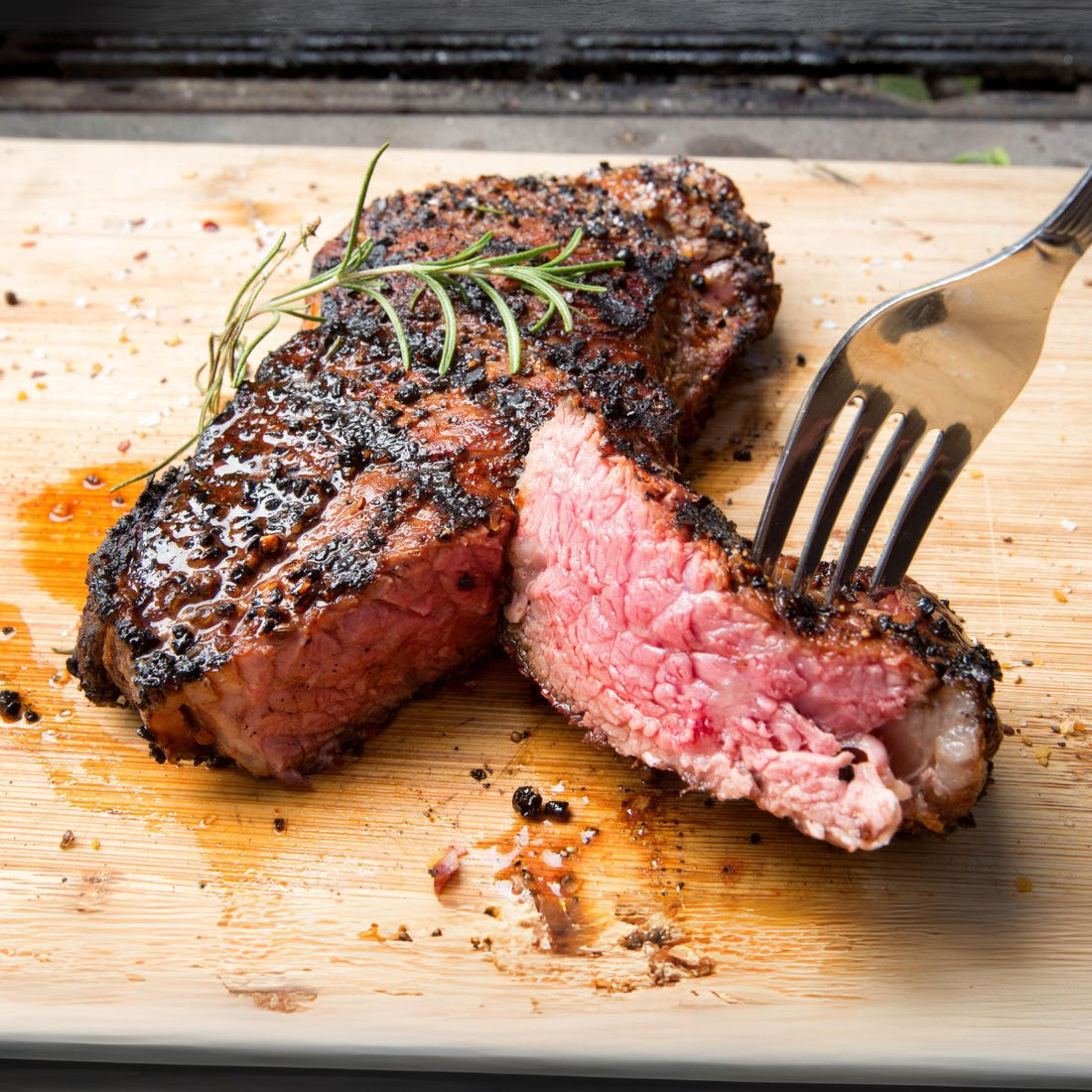 Sliced new york strip steak over wood cutting board