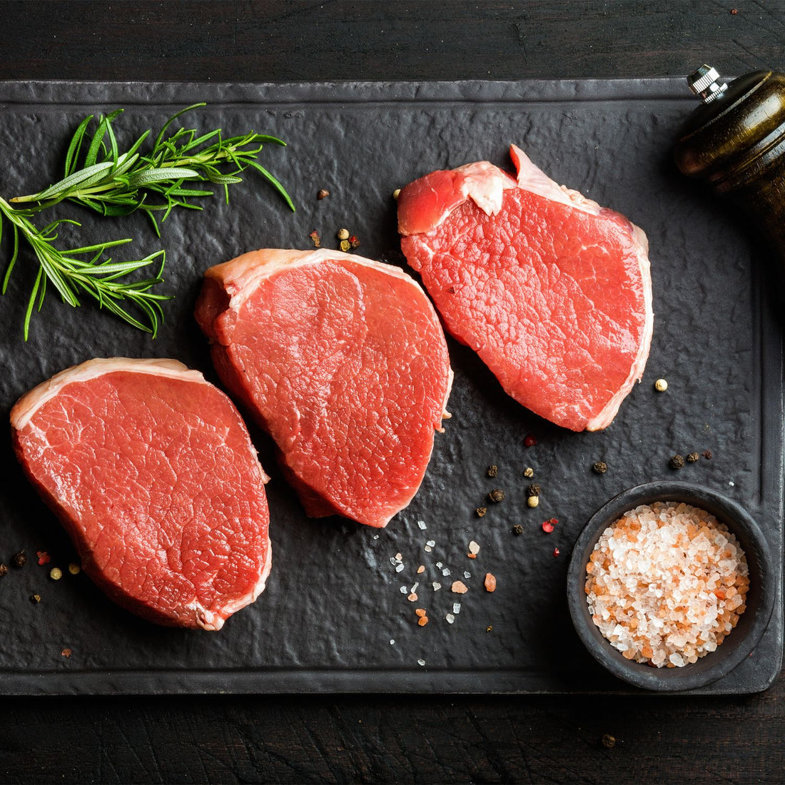 three raw eye round steaks with a sprig of rosemary to answer what is eye round steak