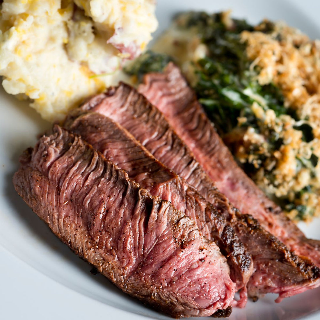 sliced london broil with side dishes from our london broil dutch oven recipe