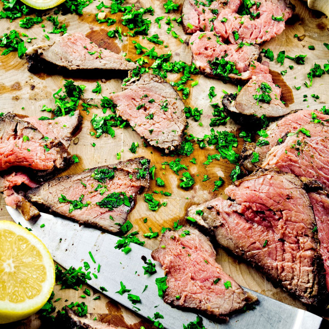 cooked sliced london broil meat garnished with cilantro and lemon for london broil tacos recipe