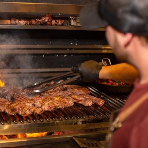 man smoking meat in a meat smoker, best gifts for meat smoker