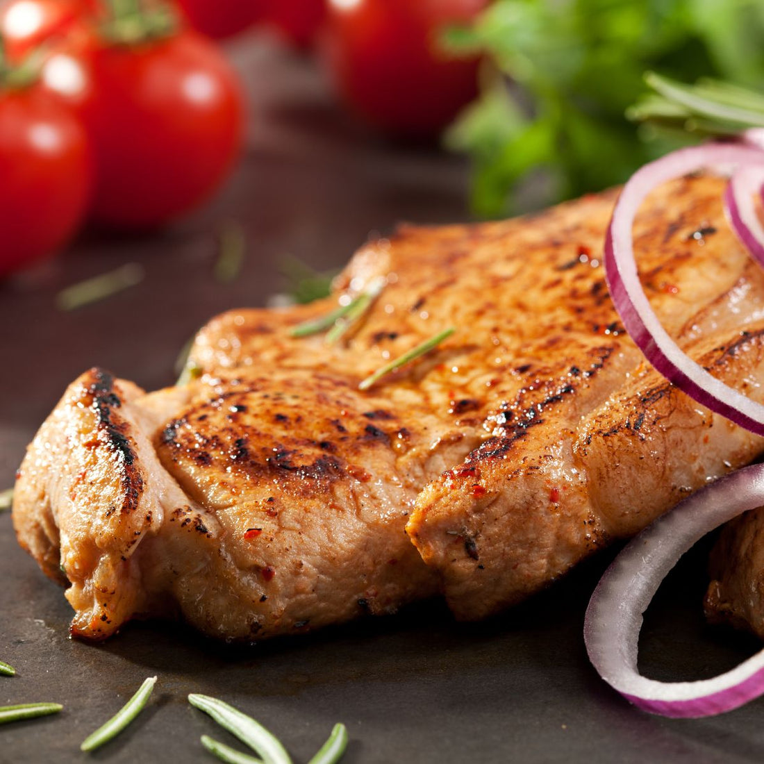 grilled and finished pork with tomatoes, rosemary, and red onions to show what is pork flank steak