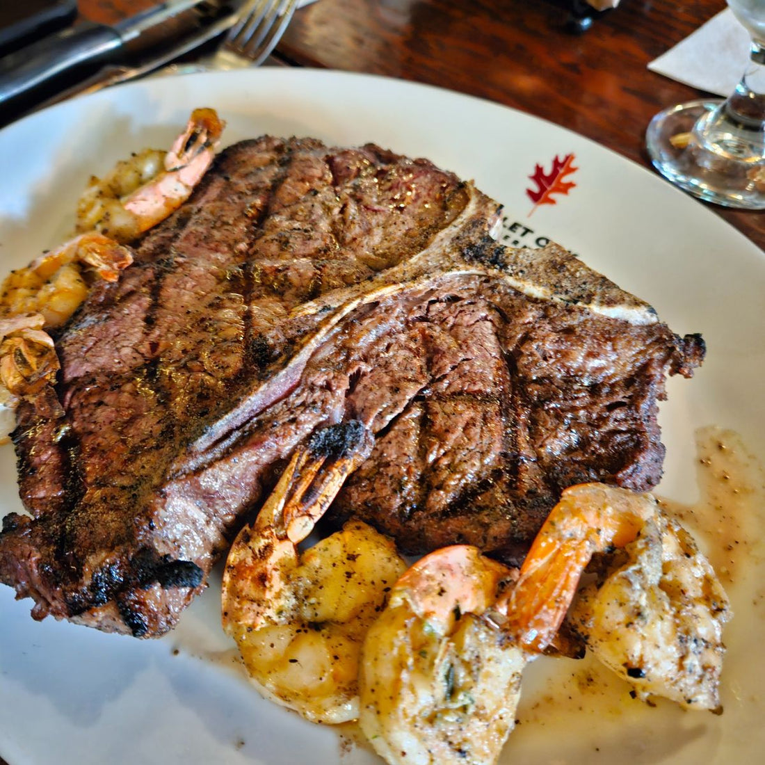 Cooked porterhouse steak with shrimps over a plate