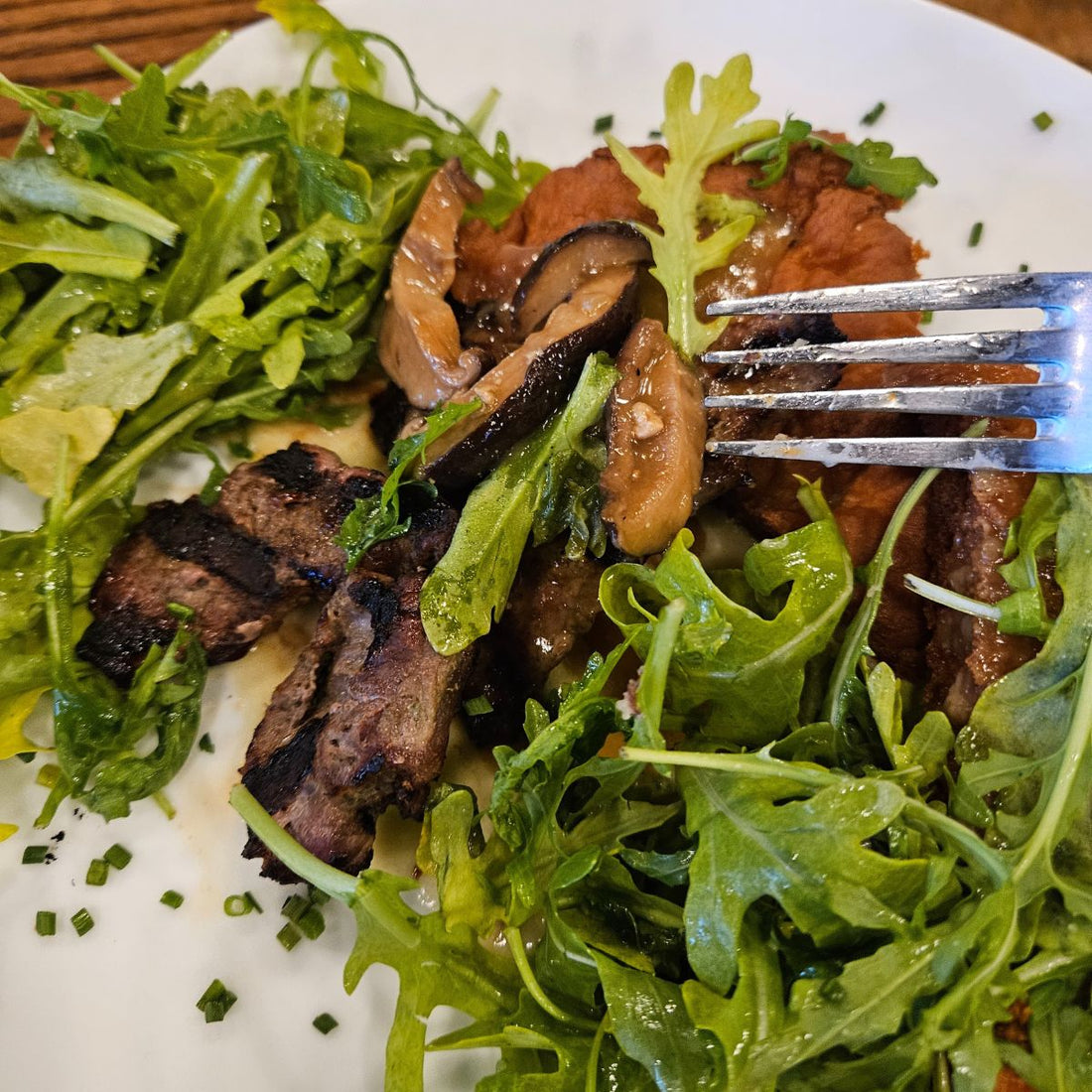 Sirloin steak slices on a arugula salad