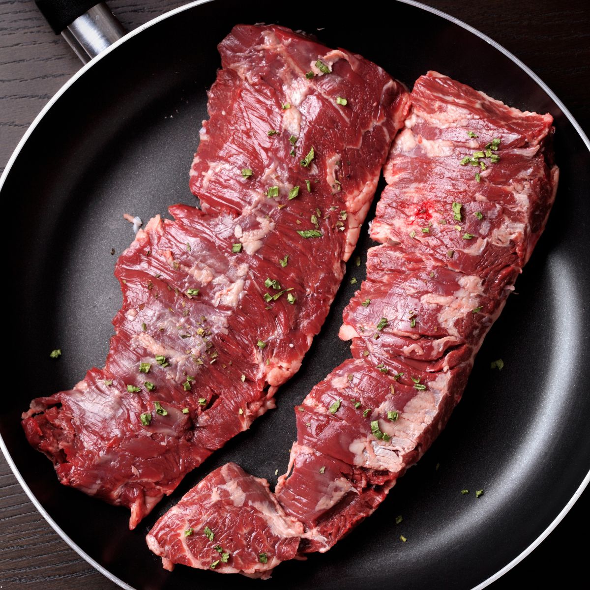 Top view of two raw skirt steaks on a pan