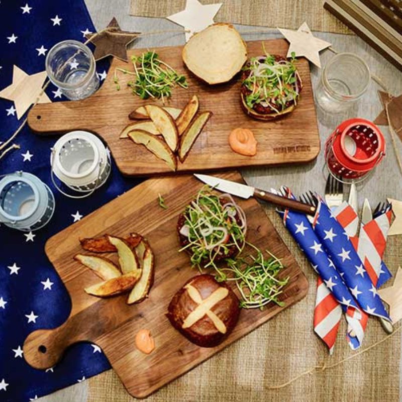 2 wooden cutting boards with handle and bread and fruit on patriot display background